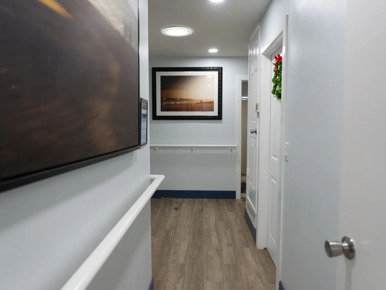 Well-lit hallway in residential care facility with accessible features and homey decor
