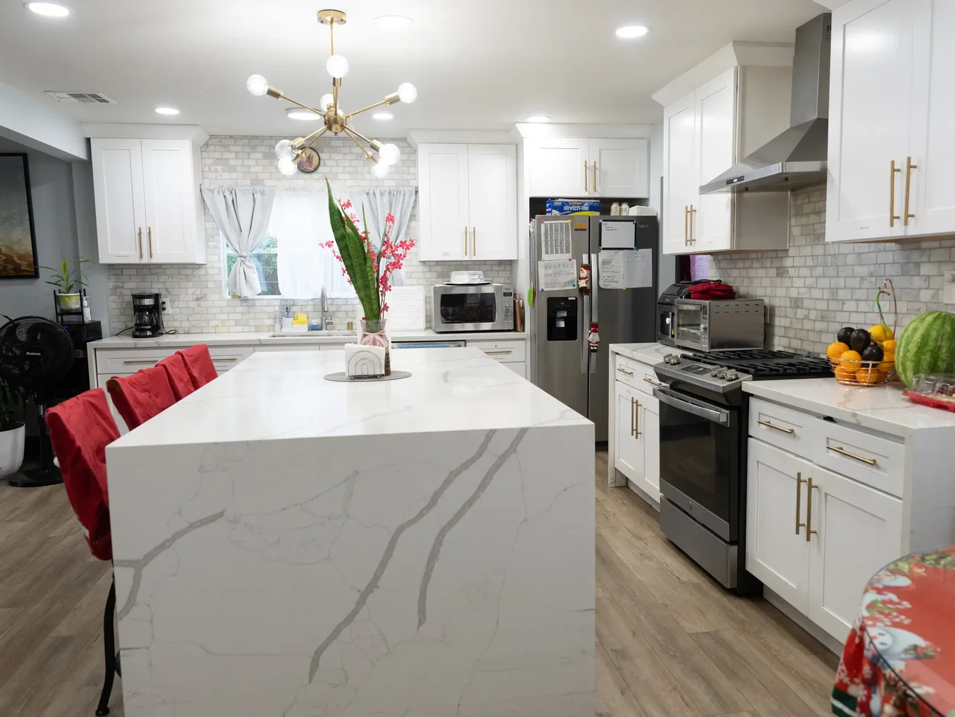 Spacious accessible kitchen with white cabinetry, marble island, and modern appliances in residential care home